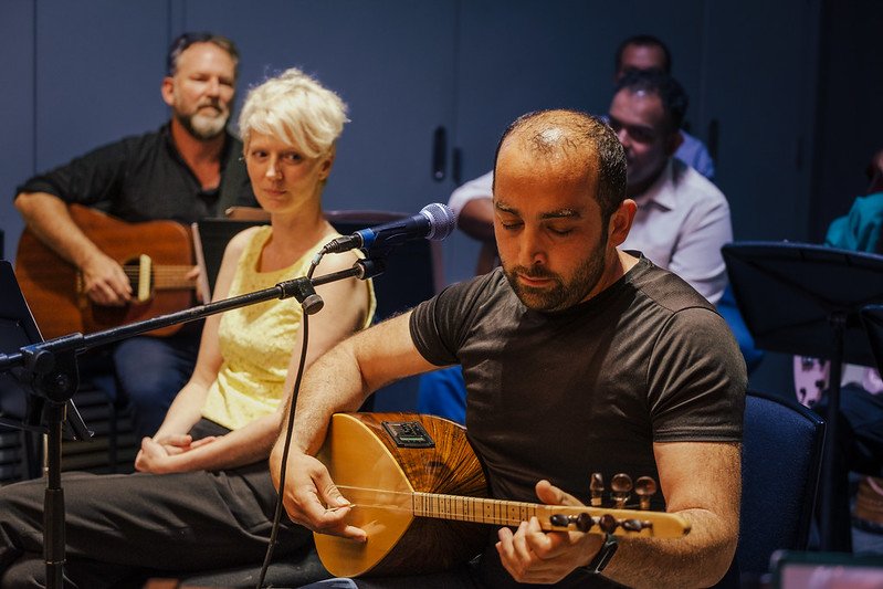Özcan Ates playing the guitar at the dovetail orchestra concert